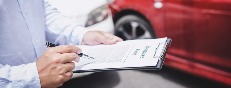 Insurance agent working on report form with car accident claim process.