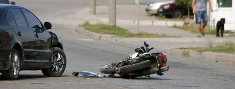 Car and motorbike accident on road