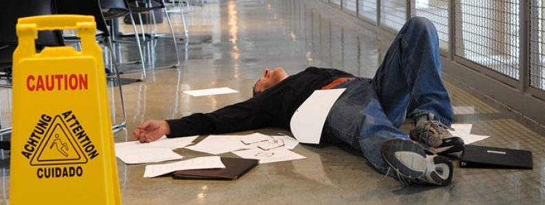 Man lying on floor in a hospital hallway after a fall.