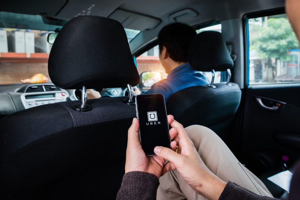 Passenger using the Uber app inside a rideshare vehicle in Hialeah, Florida, representing the growing use of rideshare services and potential accident risks.