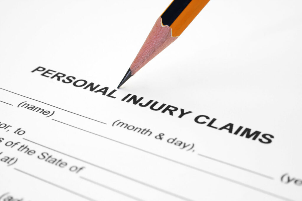 A close-up of a personal injury claim form with a pencil poised to fill in the details.