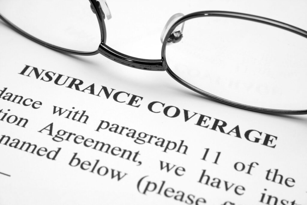 Eyeglasses on insurance coverage document, symbolizing Uber insurance review.
