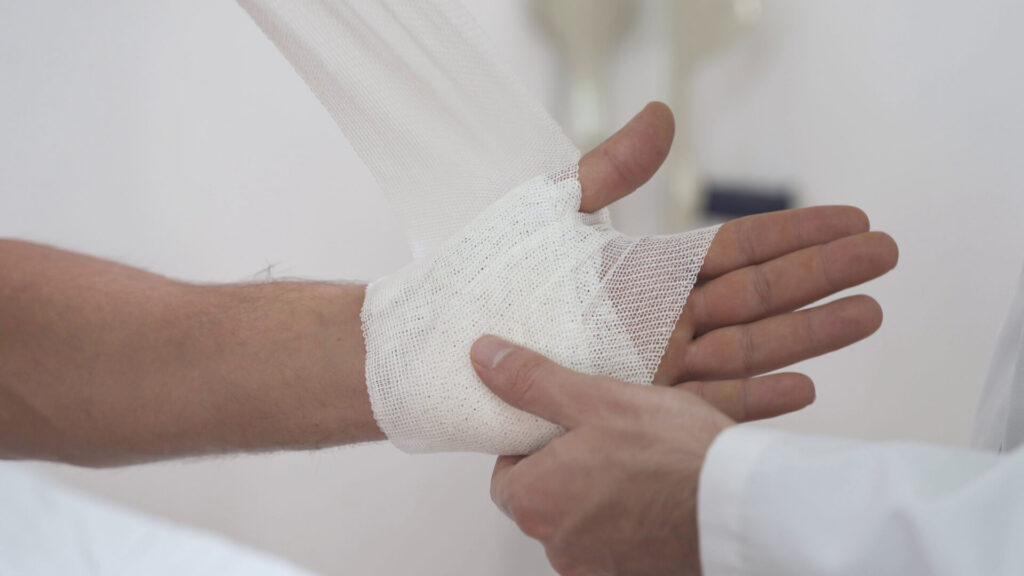 Doctor bandaging wrist, symbolizing hard-to-prove soft tissue injuries