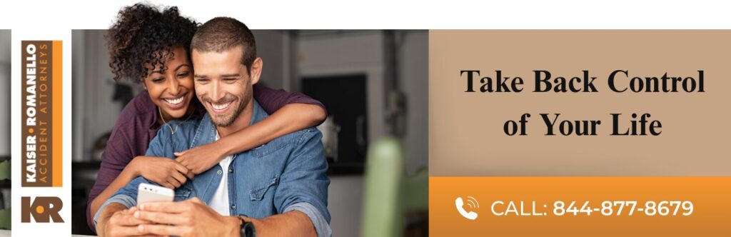Advertisement featuring a smiling couple with one person holding a smartphone, alongside text promoting legal services from Kaiser Romanello Attorneys with a phone number.