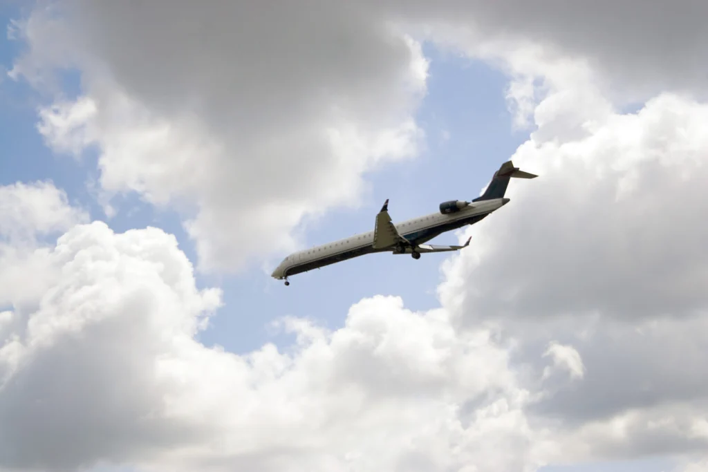 A commercial passenger jet descends toward landing under a partly cloudy sky, symbolizing the complexity of aviation accidents involving multiple liable parties in Florida.
