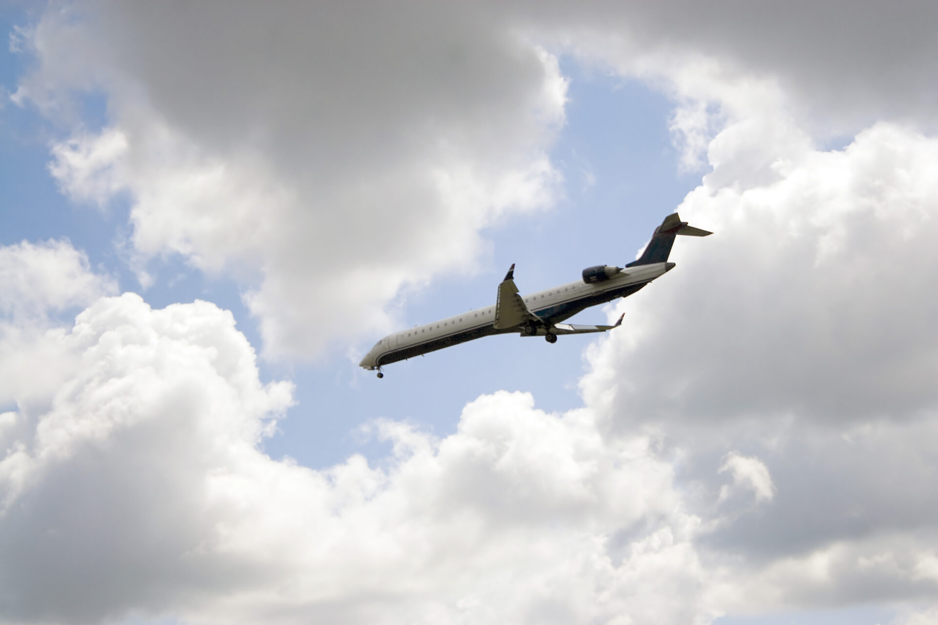 A commercial passenger jet descends toward landing under a partly cloudy sky, symbolizing the complexity of aviation accidents involving multiple liable parties in Florida.