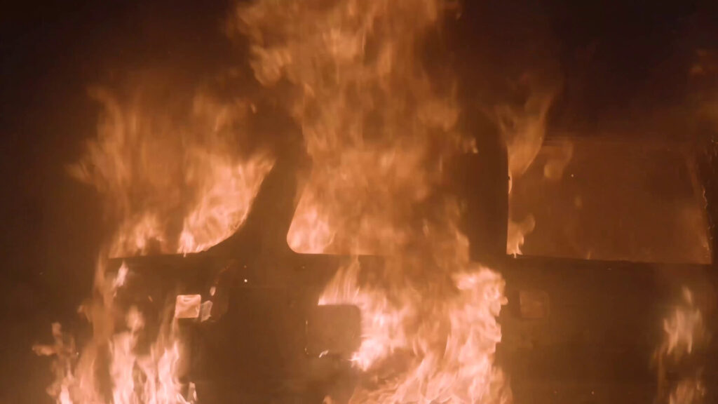 A car engulfed in flames at night, illustrating the severity of a crash similar to the Delray Beach incident, highlighting the need for a car accident lawyer.
