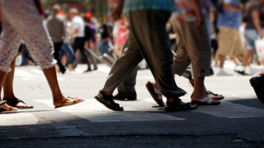 Pedestrians crossing FL crosswalk, sunny urban scene,call 844-877-8679.