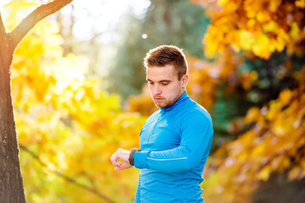 Man checking watch with a blurred bicycle accident scene in the background on a Florida road