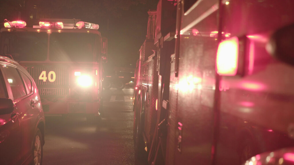 Emergency fire trucks at a nighttime crash scene on I-95 near Melbourne, Florida, assisting car accident victims.