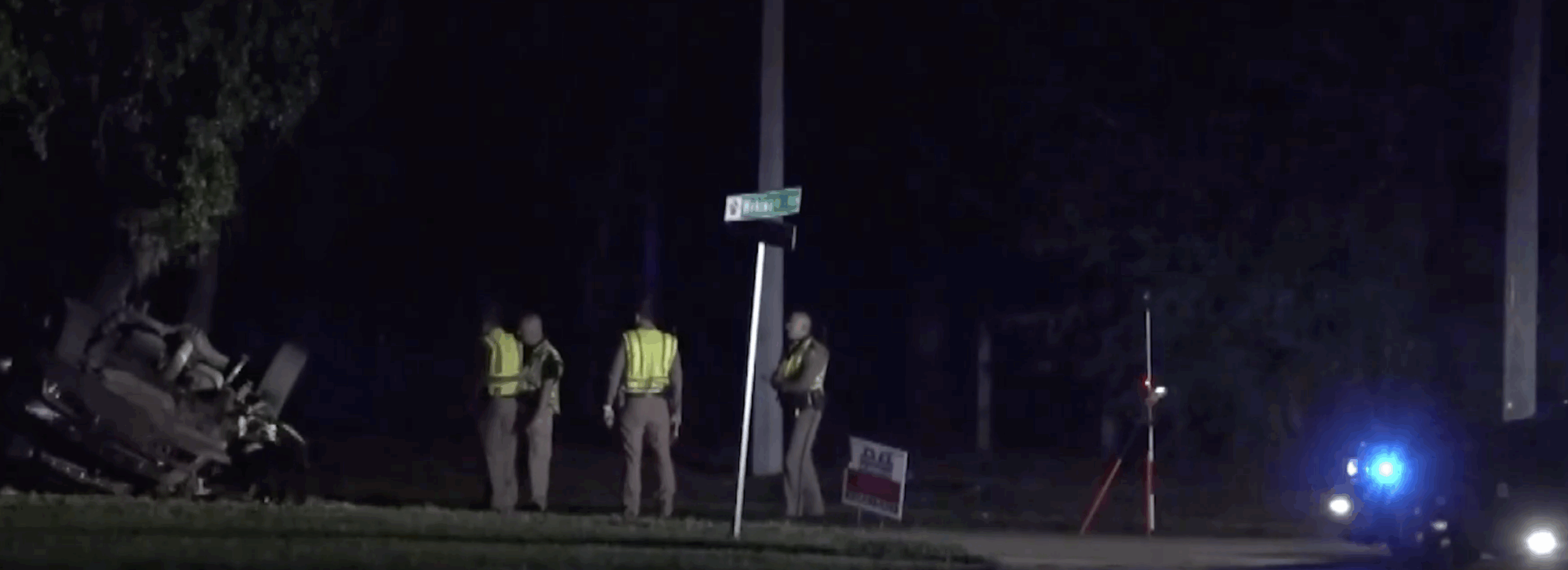 Overturned Chevrolet Silverado after fatal Apopka rollover crash at night; FHP troopers investigate near Wekiwa Drive sign.