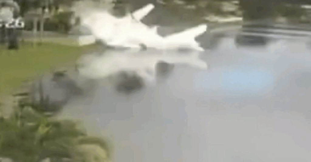 Small plane wreckage partially submerged in a Coral Springs retention pond after crashing on November 10, 2025.