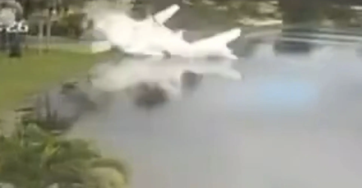 Small plane wreckage partially submerged in a Coral Springs retention pond after crashing on November 10, 2025.