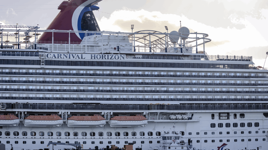 Carnival Horizon cruise ship docked with red whale-tail funnel and multiple decks visible.