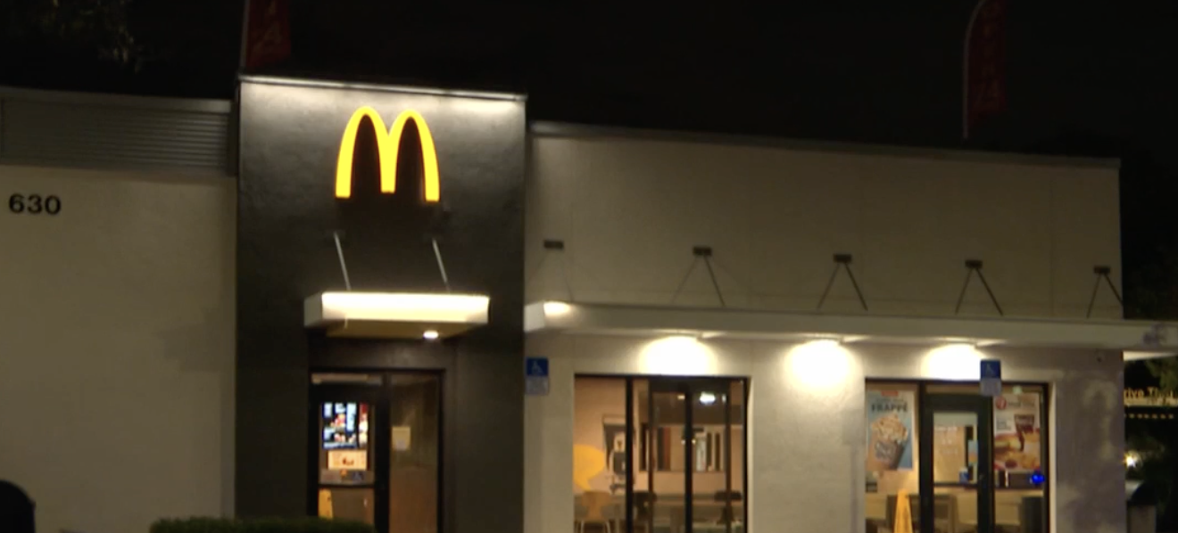 Nighttime view of the illuminated McDonald’s golden arches at the 24-hour restaurant located at approximately 630 West Sample Road in Pompano Beach, Florida, site of the fatal shooting on November 25, 2025.