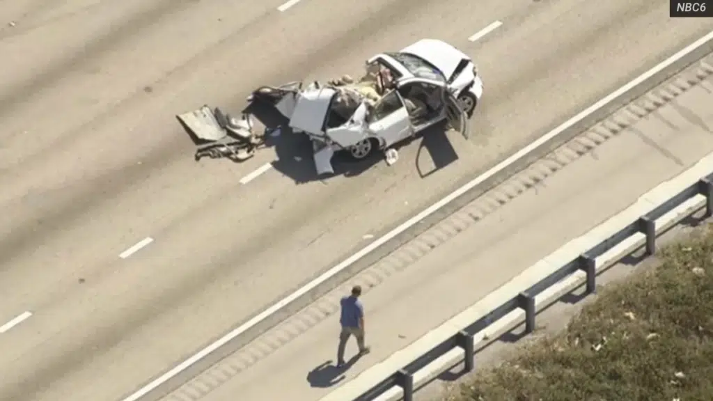 Aerial view of a white passenger vehicle with catastrophic rear-end damage on southbound I-95 in Pompano Beach Florida after a fatal crash on February 20 2026