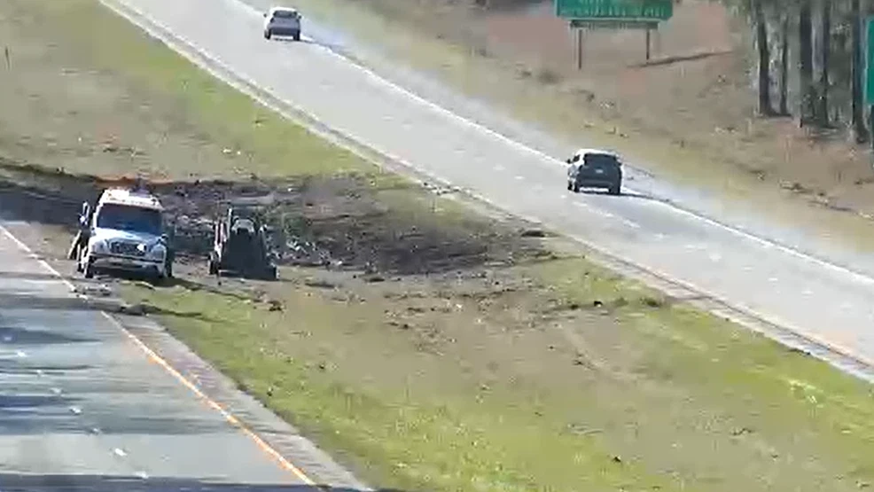 Aerial view of the I-10 tractor-trailer crash scene in Walton County, Florida, showing emergency vehicles and an overturned SUV in the median near mile marker 86