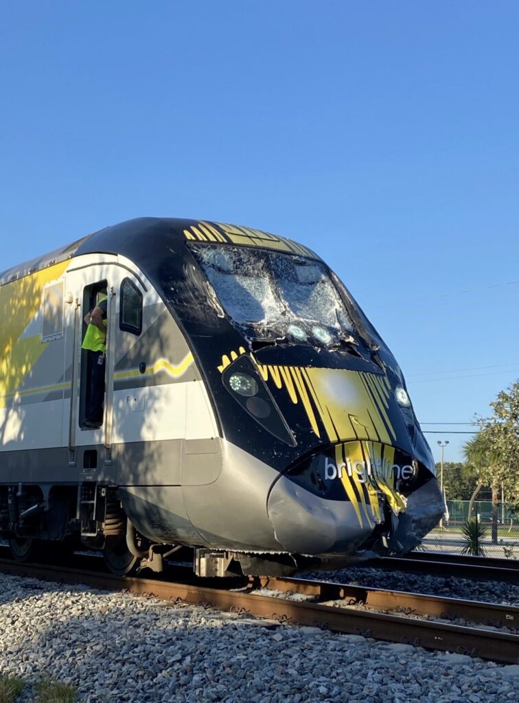 Damaged Brightline passenger train with shattered windshield and crushed front nose after a Florida railroad crossing collision