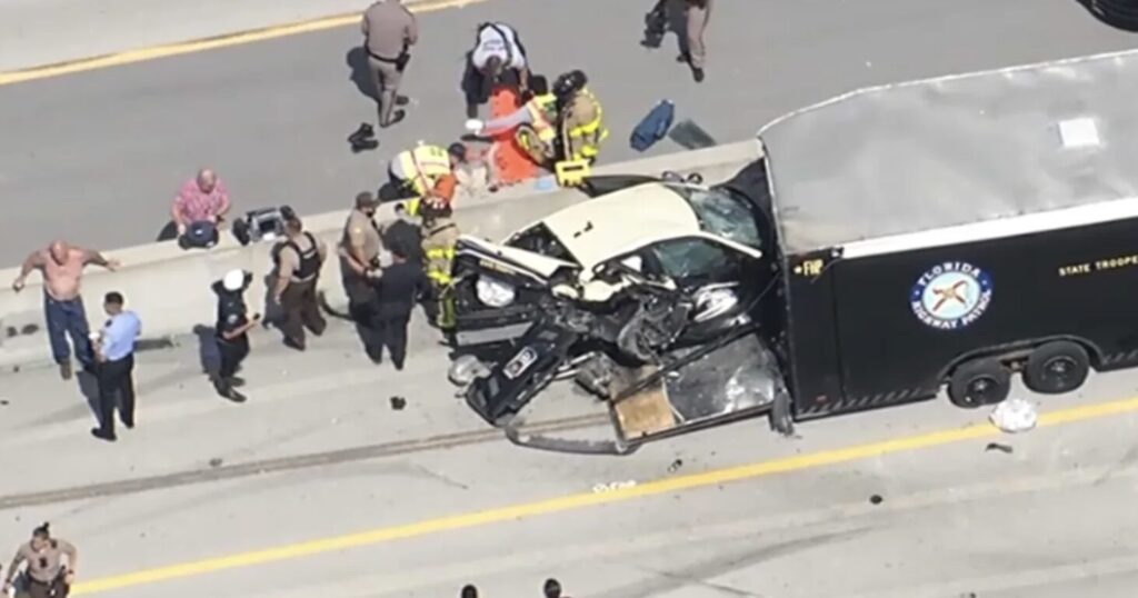 Aerial view of the June 15, 2026 Florida Turnpike crash near Medley showing a damaged Florida Highway Patrol cruiser lodged under an FHP trailer with first responders treating injured troopers on scene.
