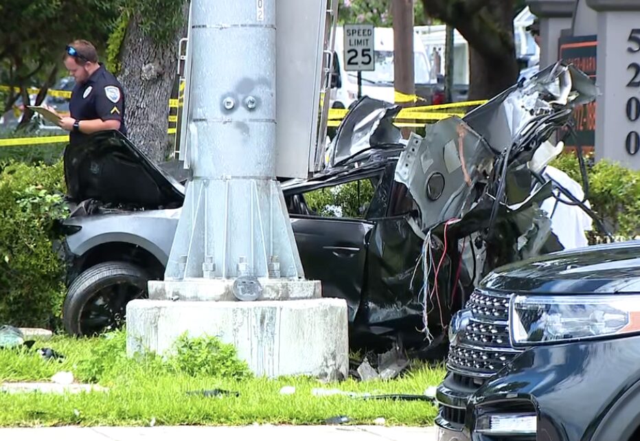 Heavily damaged vehicle wrapped around a utility pole at the fatal US 17-92 crash scene in Casselberry with police on scene